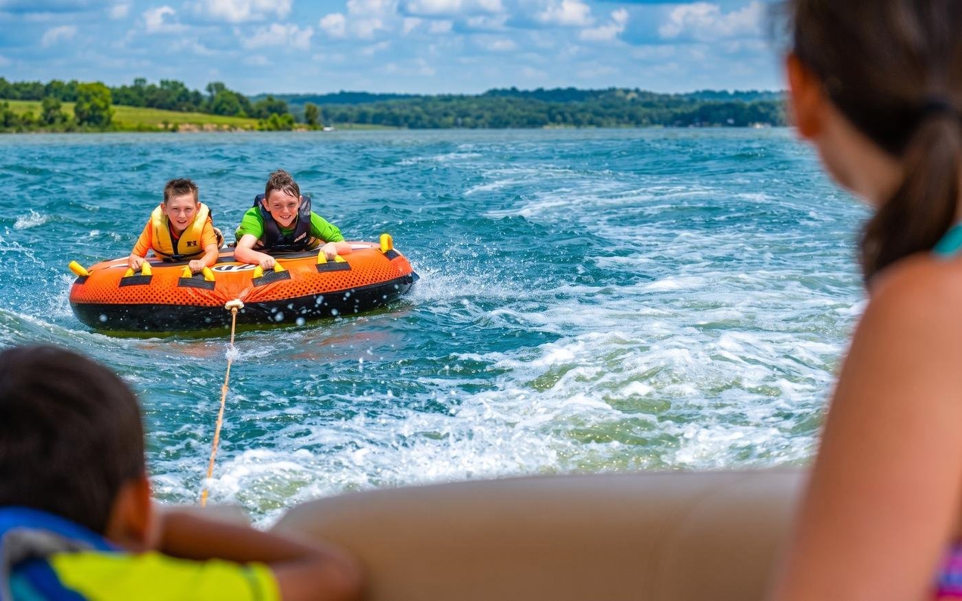 Kids tubing on Cedar Creek Reservoir behind a boat