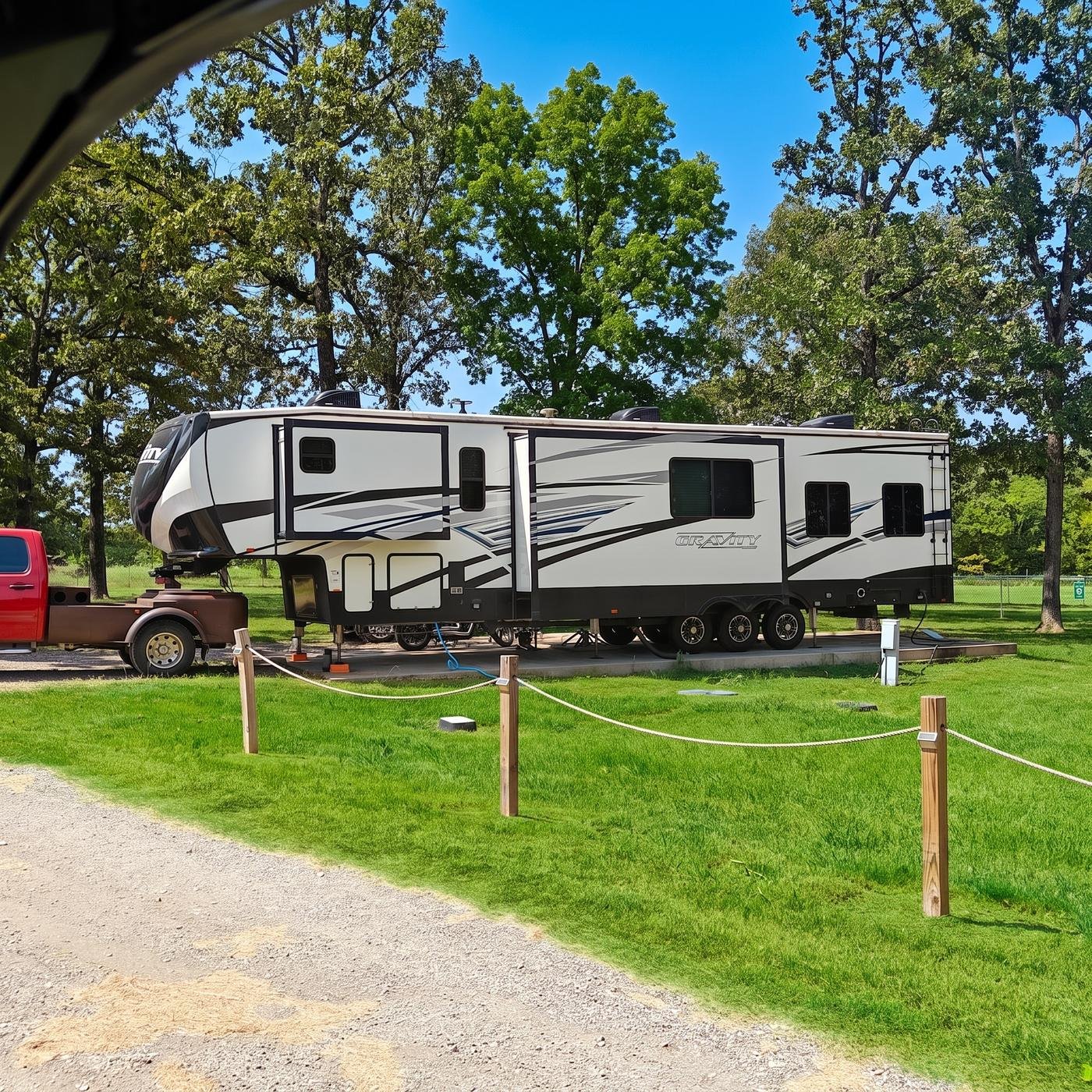 Fifth wheel trailer parked on a gravel pull-through pad