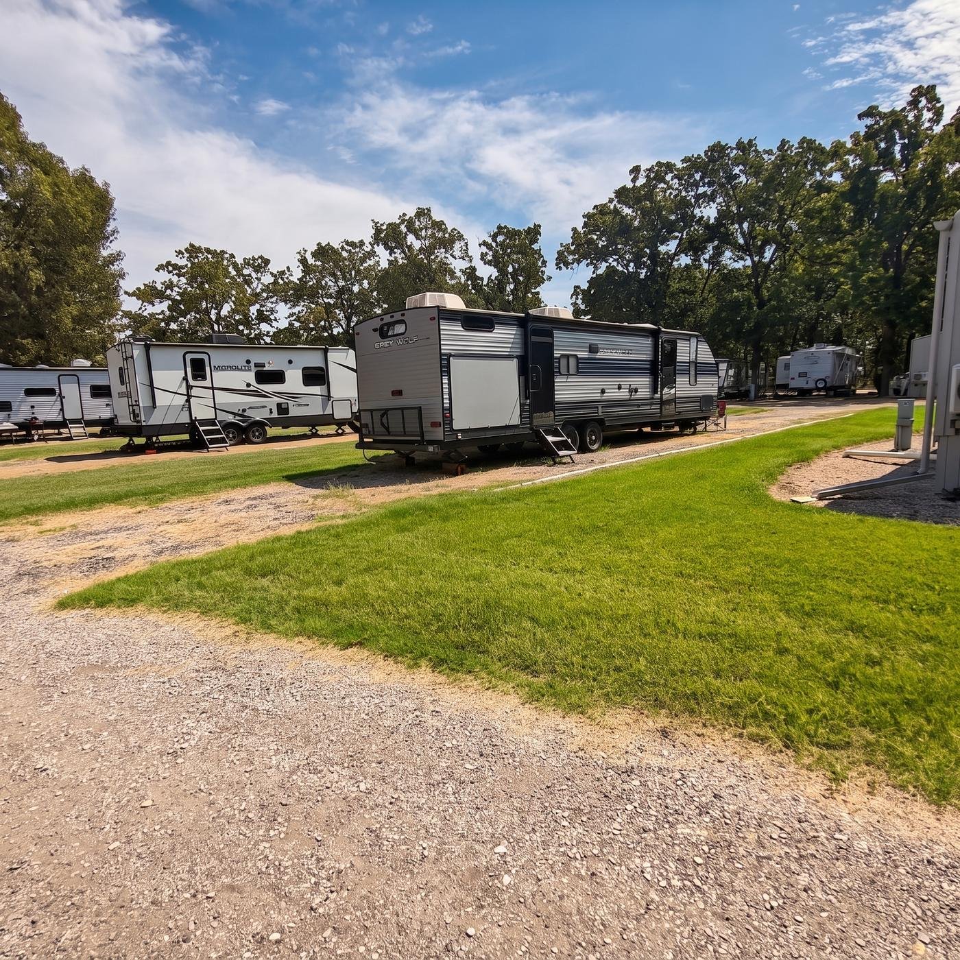Travel trailer parked under shade trees