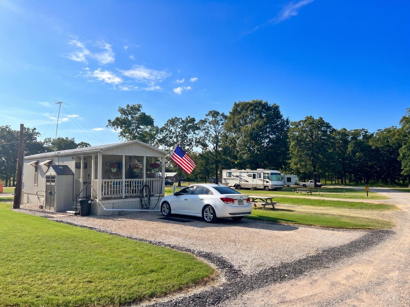 Tiny home with a covered front porch and flag